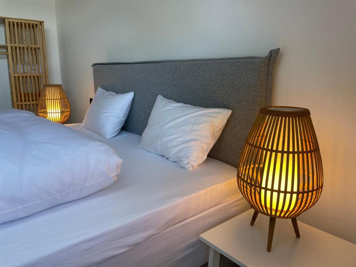 Graues Doppelbett mit Holzlampen auf dem Nachttisch